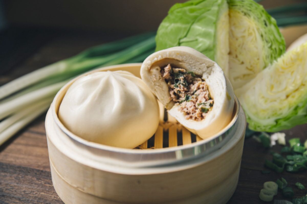 孔子饅頭【招牌鮮蔥肉包】內餡特寫，可見新鮮黑毛豬肉與翠綠青蔥、湯汁飽滿。