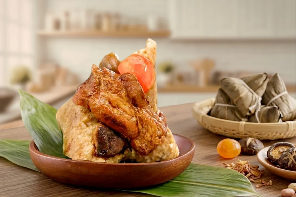 孔子饅頭滿福招財粽，剝開粽葉展示爌肉、鹹蛋黃、鹵香菇等豐富內餡，置於木盤與竹葉上，背景有整顆綁繩肉粽與香菇、蛋黃食材散落，古早味南部肉粽。